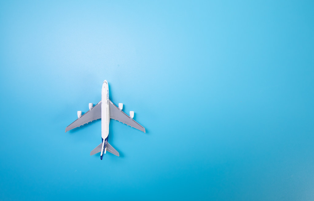 Miniature white airplane on a blue background. Horizontal … - Flickr