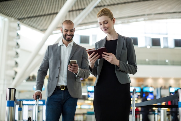 Free photo businesspeople waiting in queue at a check-in counter with luggage