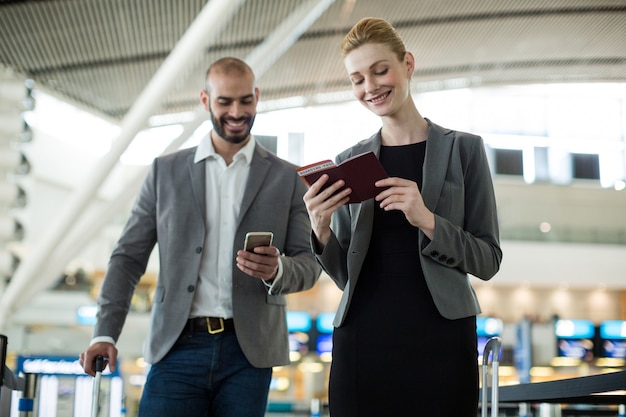 Free photo businesspeople waiting in queue at a check-in counter with luggage