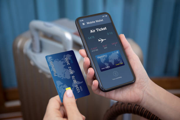 female hands hold phone airplane ticket application airlines credit card female hands hold phone with airplane ticket application airlines on screen and credit card on background of luggage at airport airline flight ticket stock pictures, royalty-free photos & images