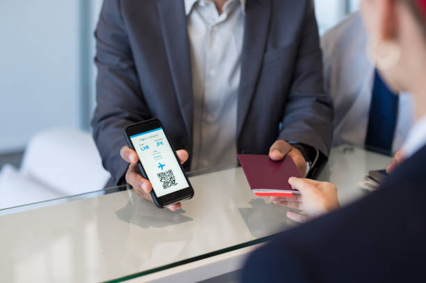 Man showing electronic flight ticket Closeup hand of man showing flight ticket to staff on phone. Hostess checking electronic flight ticket. Airport check in counter and online air ticket. airline flight ticket stock pictures, royalty-free photos & images