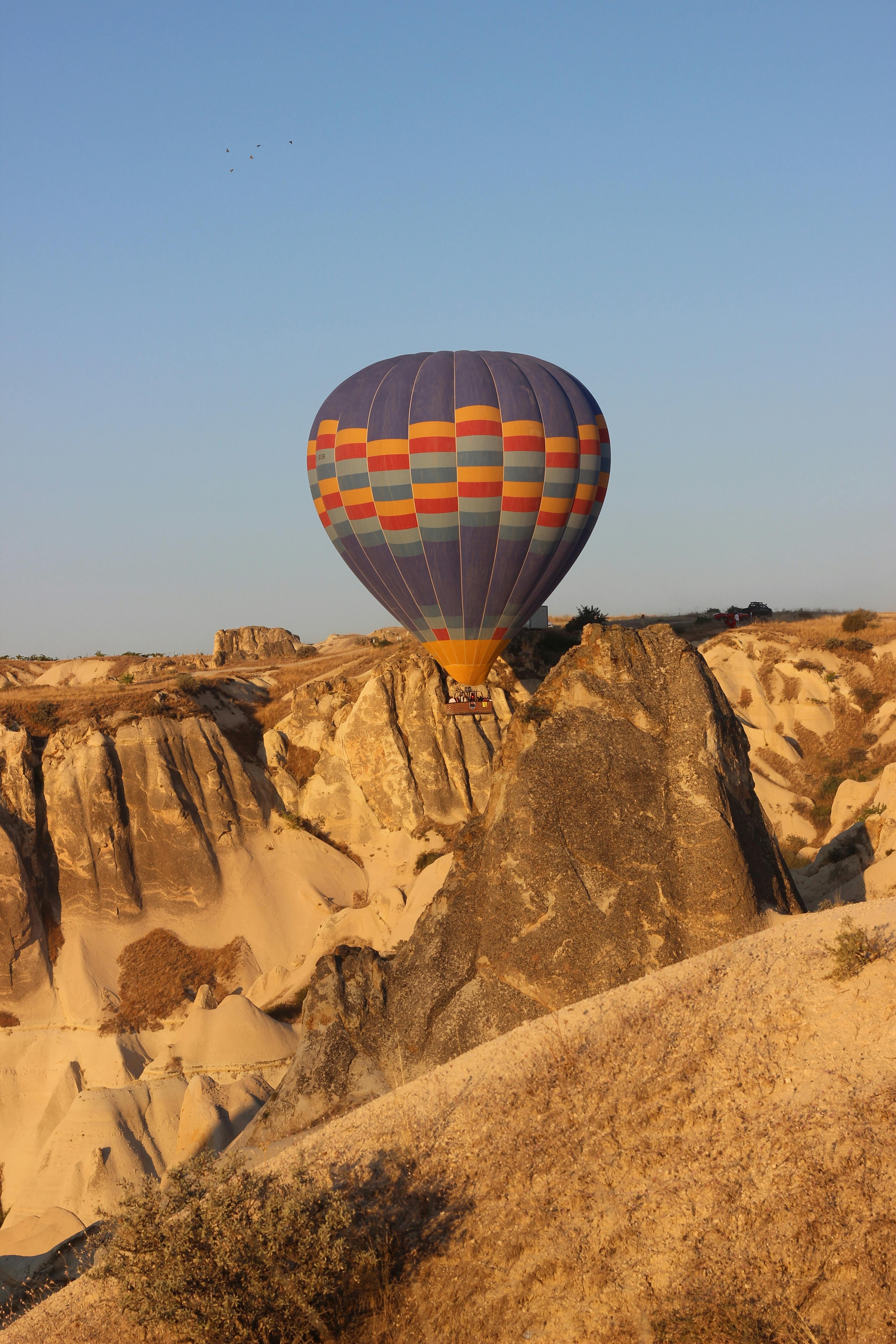 colorful hot air balloon flying over rock formations