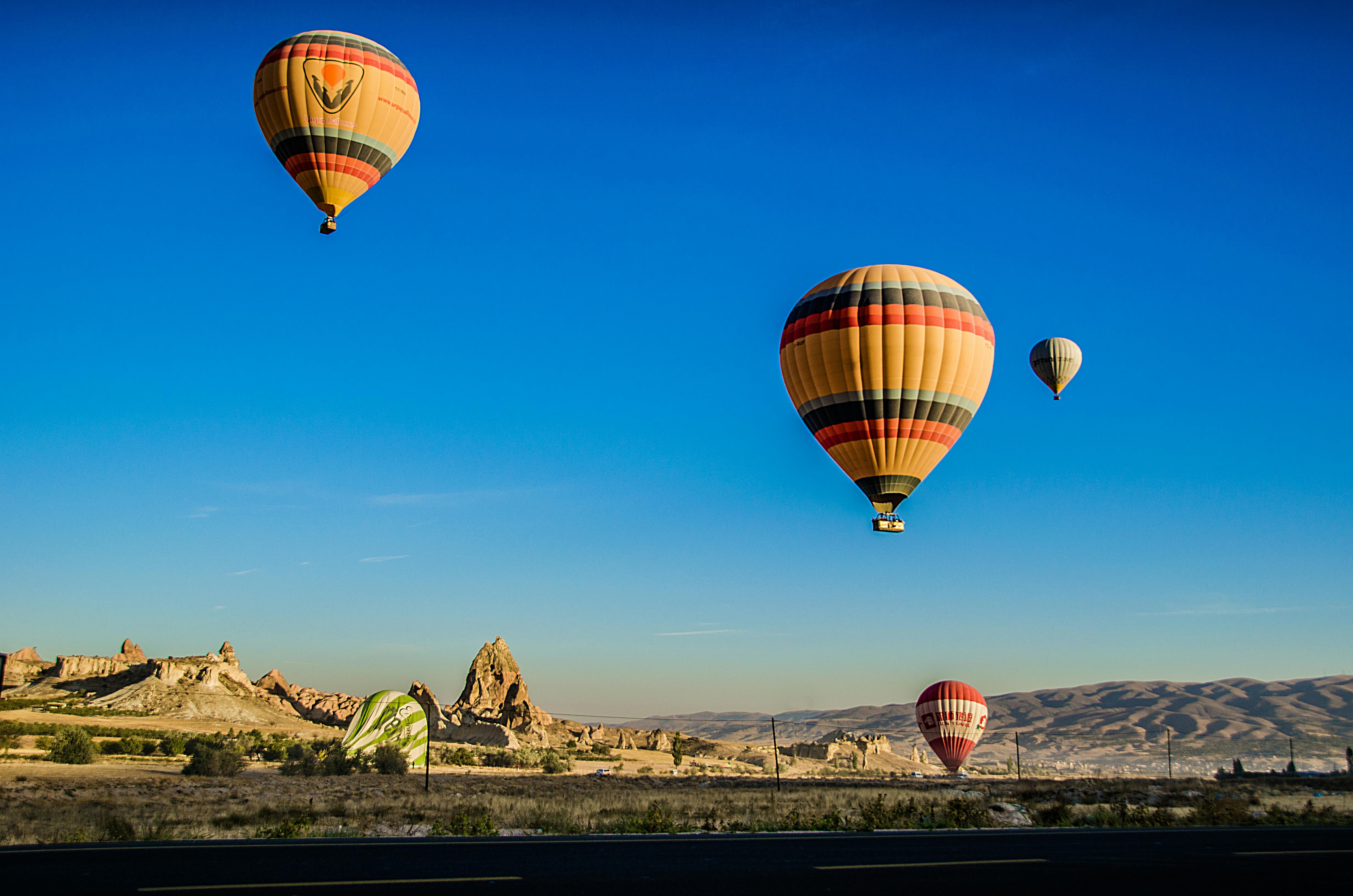 four beige hot air balloons flying