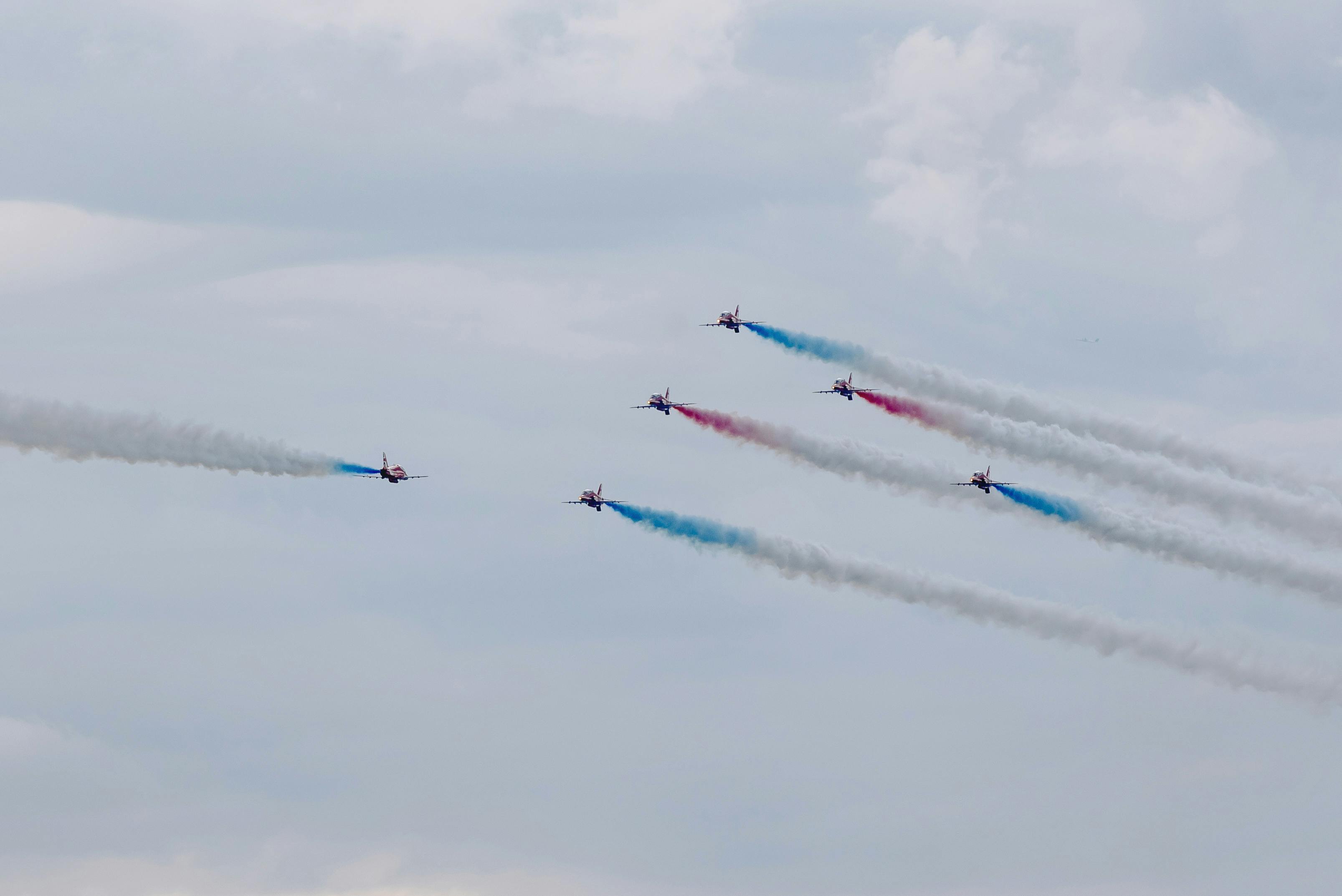 air show with planes performing traces in cloudy sky
